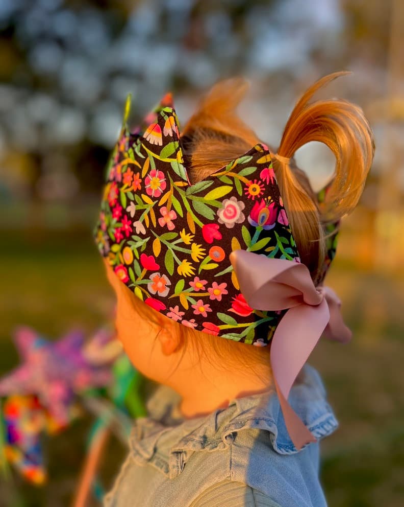Young child wearing a dark floral handmade birthday crown at sunset
