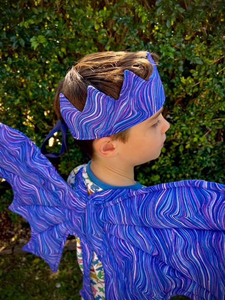 A child wearing amethyst dragon wings with a matching fabric crown