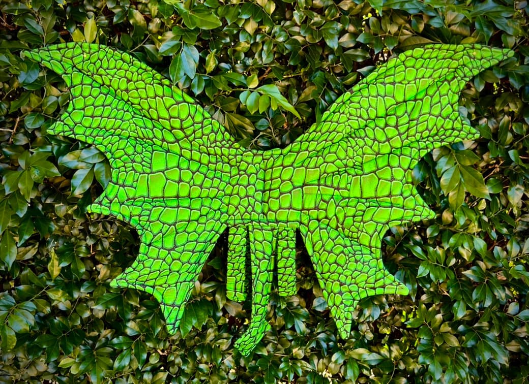 Emerald Scale handmade dragon wings displayed against deep green leaves